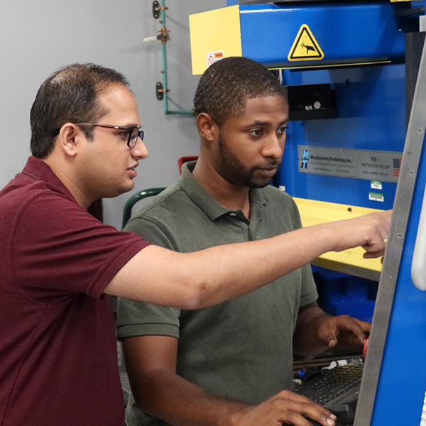 UNT post doctoral researcher Saurabu NeNe (left) and graduate research assistant Michael Frank monitor the Stir Friction Process.